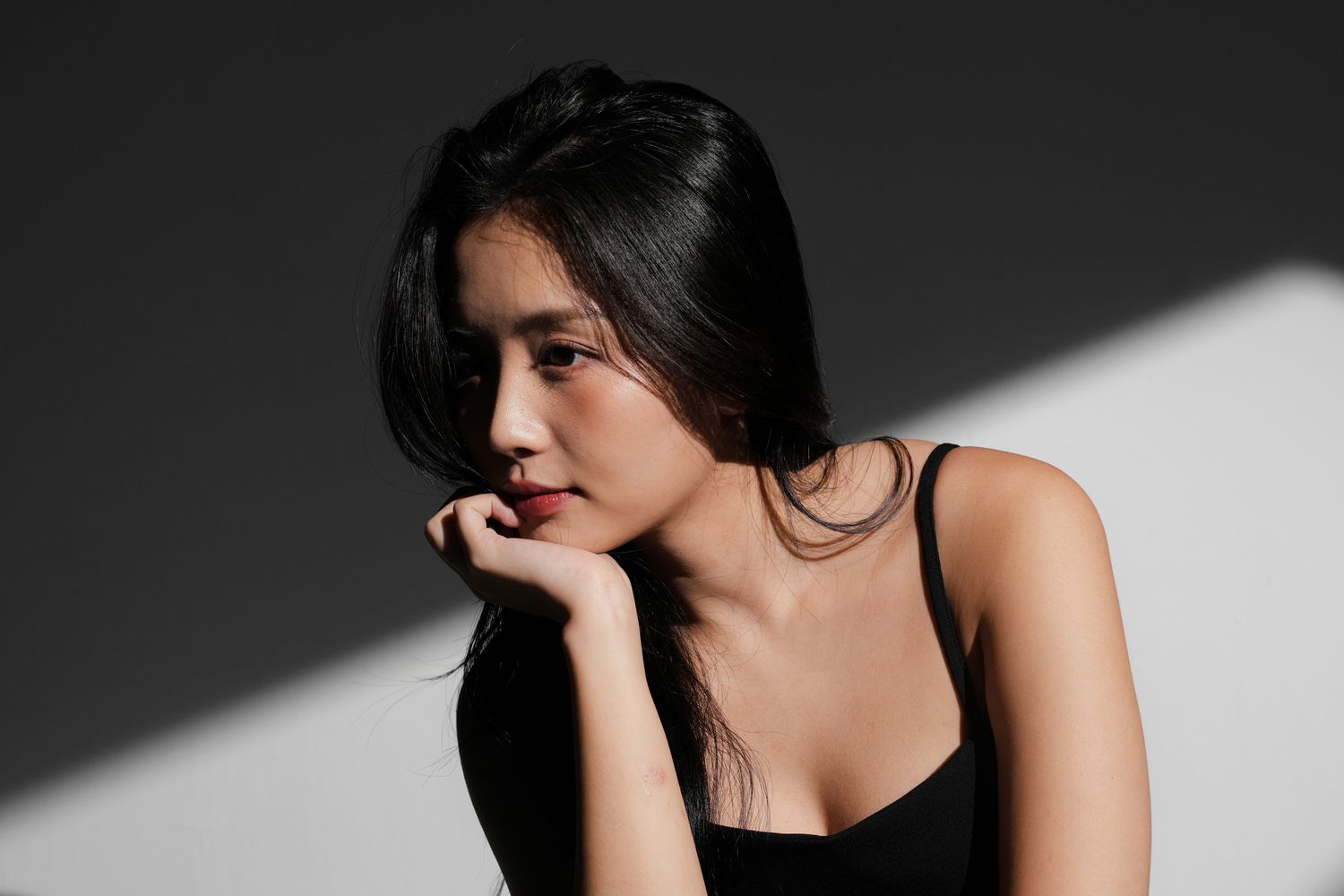 Woman in profile with thoughtful expression and light.