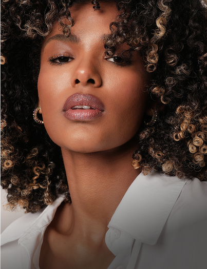 Smiling man in glasses and cap, arms crossed.